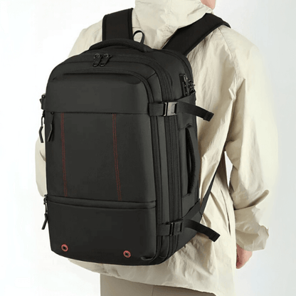 Person wearing a black backpack with red accents on a white background